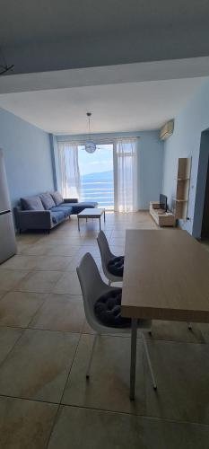 a living room with a table and a couch at Summer Breeze Apartment Saranda in Sarandë