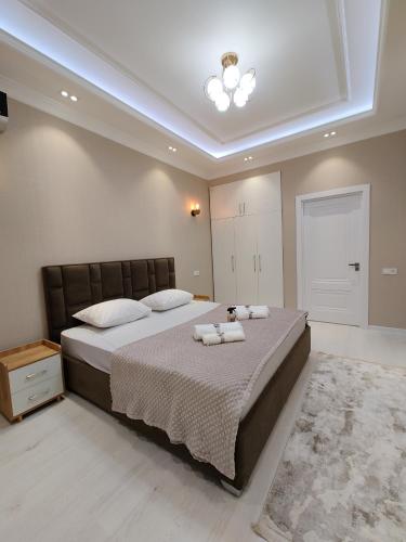 1 dormitorio con 1 cama grande y 2 toallas. en BAURUM Family Apartments, en Tashkent