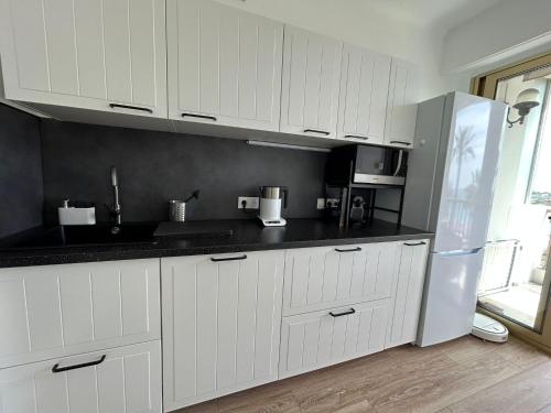 a kitchen with white cabinets and a refrigerator at La Couronne Appartement a Nice in Nice