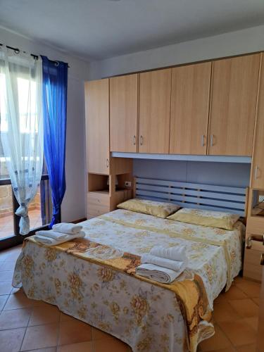 Schlafzimmer mit einem großen Bett und Holzschränken in der Unterkunft Appartamento Liam in Marzamemi