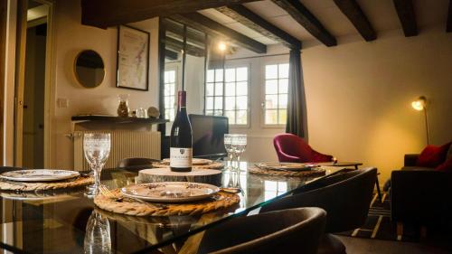 een eetkamer met een tafel met een fles wijn bij Le Sommelier Chalon in Chalon-sur-Saône