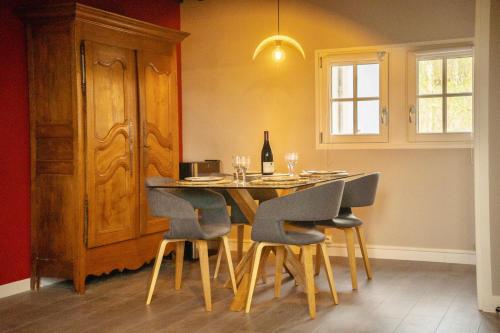 een eettafel met stoelen en een fles wijn bij Le Sommelier Chalon in Chalon-sur-Saône