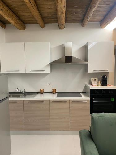 a kitchen with white cabinets and a stove at Fiera Home Verona in Verona