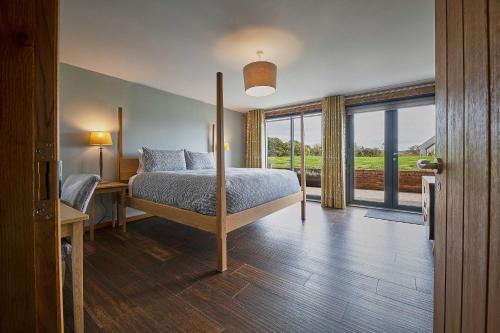 a bedroom with a bed and a large window at Woodland Barn in Durham