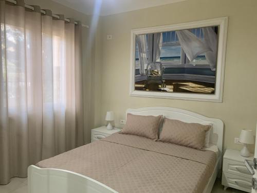 een witte slaapkamer met een wit bed en een raam bij Ferienwohnung Golem (Durres) in Golem