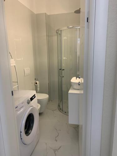 een badkamer met wasmachine en toilet bij Ferienwohnung Golem (Durres) in Golem
