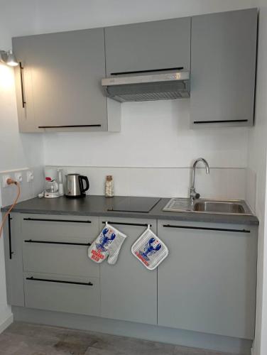 une cuisine avec des armoires blanches et un évier dans l'établissement Le Krogen, à Locmiquélic