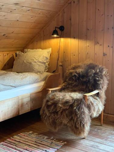 Un dormitorio con una cama con un gran reposapiés peludo en Husmannsplassen Havrebakken på Helgøya en Ringsaker