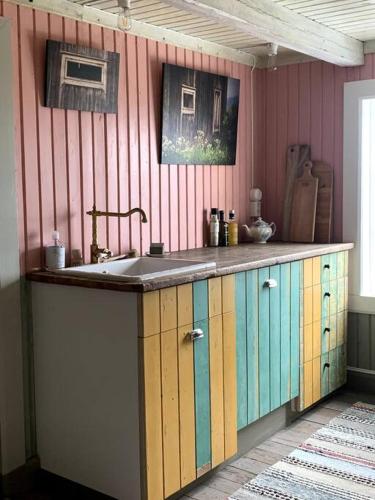 a kitchen with colorful cabinets and a sink at Husmannsplassen Havrebakken på Helgøya in Ringsaker