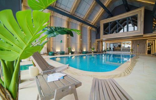 uma grande piscina com duas cadeiras e uma planta em Titova Vila S Lux em Palisat