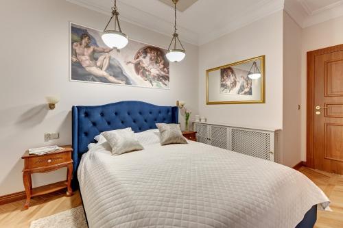 a bedroom with a blue bed with a blue headboard at Granaria by Welcome Apartment in Gdańsk