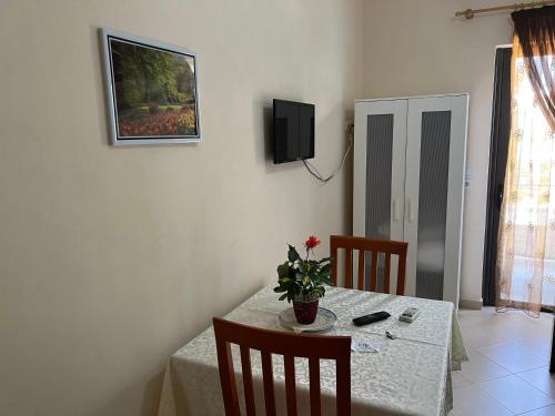 a dining room table with a vase of flowers on it at Ion Sea View in Ksamil