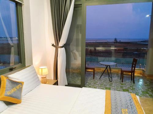 a bedroom with a bed and a large window with a view at Seaside Hotel - Rach Gia in Rach Gia