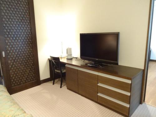 a hotel room with a television on a desk at Kyu Karuizawa Hotel Otowa No Mori in Karuizawa