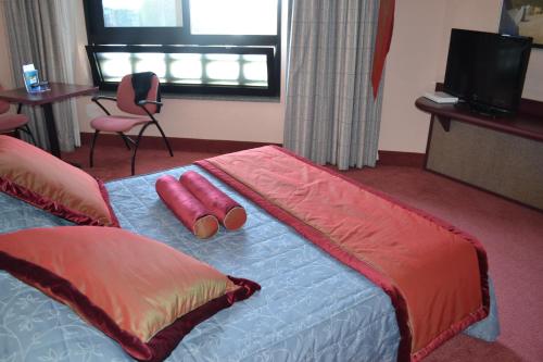 a hotel room with a bed with two pillows on it at Gotha Hotel Turin Airport in Ciriè