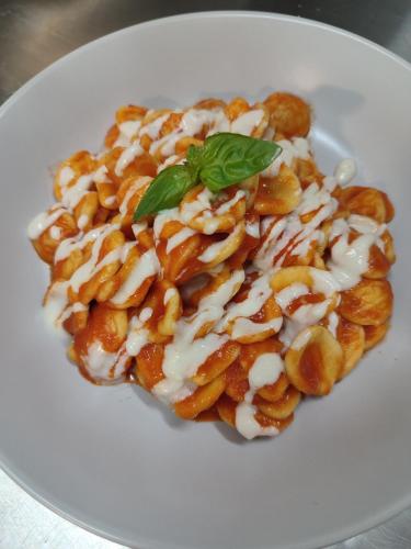 a white plate with a dish of food with a green leaf at B&B Giardino Isabella in Palagiano