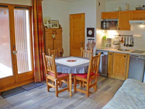 une cuisine avec une table et des chaises dans une pièce dans l'établissement Appartement cosy avec piscines, parking et WiFi à Samoëns - FR-1-629-32, à Samoëns