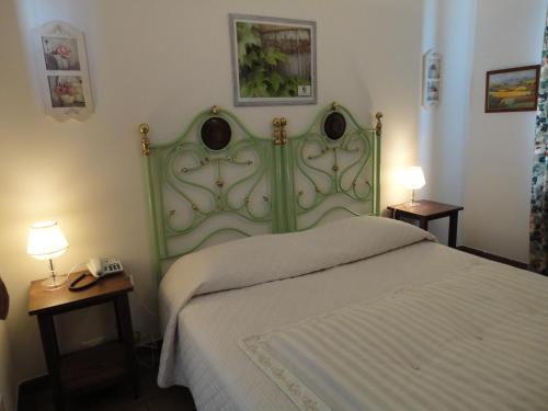a green bed in a bedroom with two tables and two lamps at Masseria Santa Teresa in Monopoli