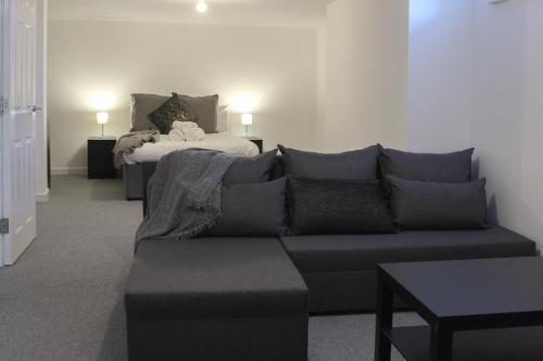 sala de estar con sofá y cama en Comfy Studio with Transport Links to MCR en Heywood
