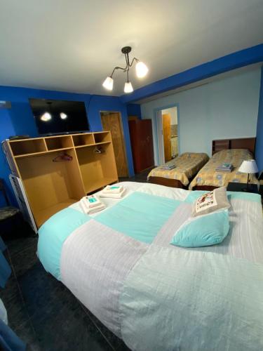 Habitación de hotel con 2 camas y TV en GAVIMAR en Ushuaia