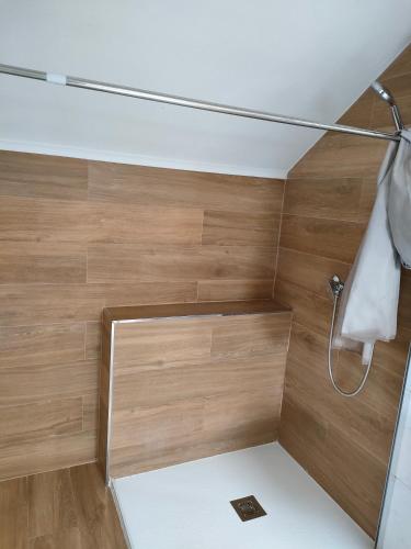 a bathroom with a shower with wooden walls at mar de rosa in Villanueva de Arosa