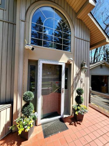 a front door of a house with two potted plants at Paradise in heart of Poconos FaSt InTeRnEt Close to All Attractions in Pocono Summit