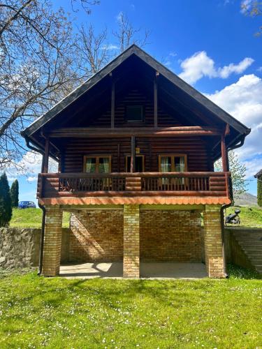 a log cabin with a deck on a lawn at Drinka in Ljubovija