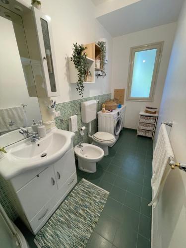 een badkamer met een wastafel, een toilet en een spiegel bij Grazy House in Marina di Modica