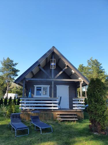 a small house with blue chairs in front of it at Szteklin os. Nowe in Szteklin