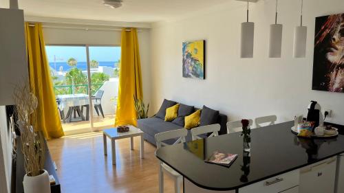 uma sala de estar com um sofá e uma mesa em El Sueño Ocean Lanzamar - Puerto Del Carmen em Puerto del Carmen