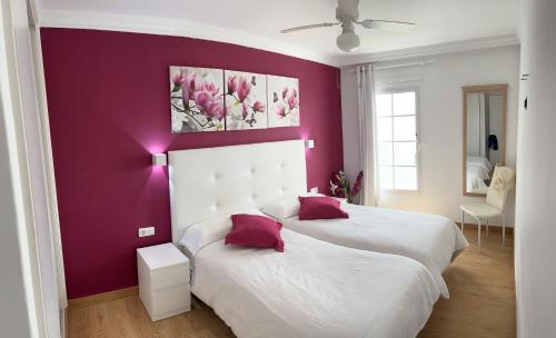 two beds in a bedroom with a purple wall at El Sueño Ocean Lanzamar - Puerto Del Carmen in Puerto del Carmen