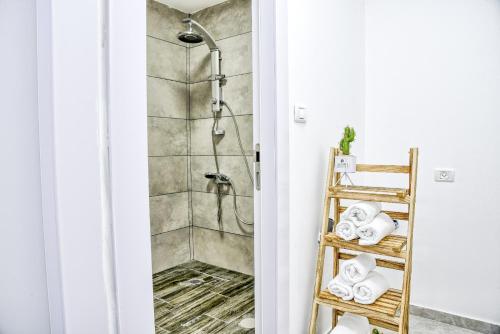 a bathroom with a shower and a ladder with towels at Galilee Hills - Resort & Suites in Maghār