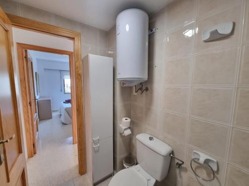 ein Badezimmer mit Toilette, Waschbecken und Spiegel in der Unterkunft BONITO APARTAMENTO EN PLAYA DE GANDIA in Playa de Gandia