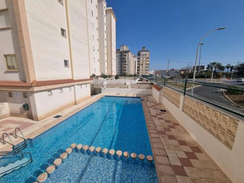 ein Swimmingpool an der Seite eines Gebäudes in der Unterkunft BONITO APARTAMENTO EN PLAYA DE GANDIA in Playa de Gandia