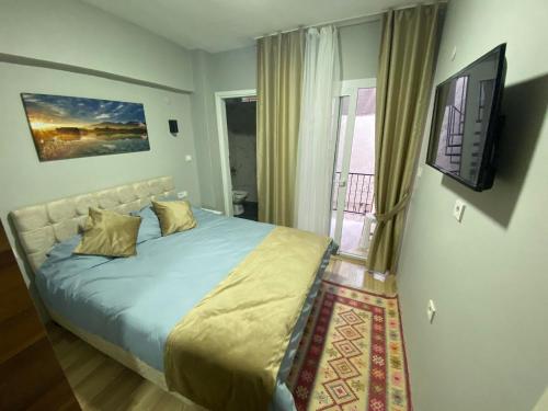 a bedroom with a bed with a television and a balcony at GÜLERSU PANSIYON in Kusadası