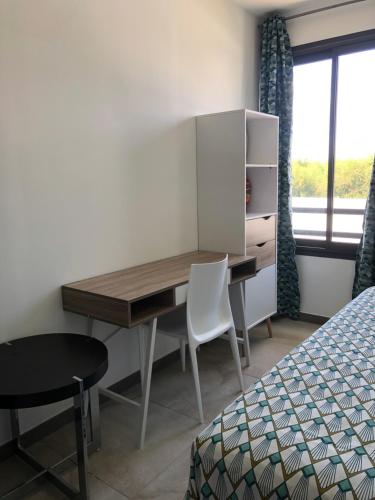 a bedroom with a desk and a bed and a window at Villalina : Cosy, piscine privée, proche Grand Baie et plages in Pereybere