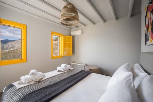a white bedroom with a bed and a window at Serenity Beach Villa - Port View in Livadakia