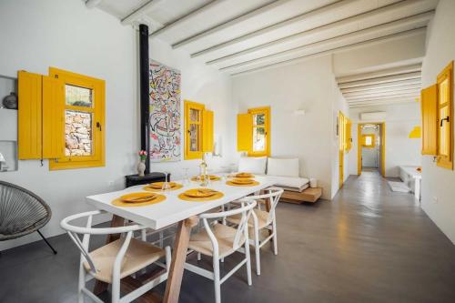 a white dining room with a white table and chairs at Serenity Beach Villa - Port View in Livadakia