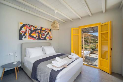 1 dormitorio con 1 cama con toallas en Serenity Beach Villa - Port View, en Livadakia