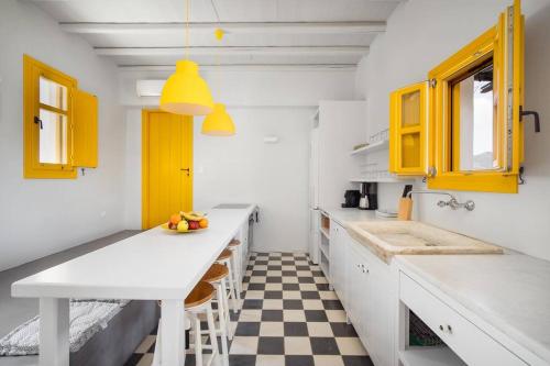 cocina con armarios amarillos y suelo a cuadros en Serenity Beach Villa - Port View, en Livadakia