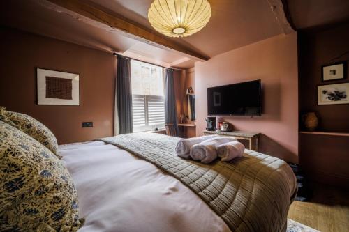 um quarto com uma cama com duas toalhas em The Silk Rooms, at The Freemasons Inn em Knutsford