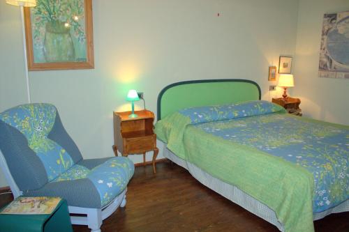 a bedroom with a bed and a chair and a bed and a couch at Il Poggio di Teo in Manciano