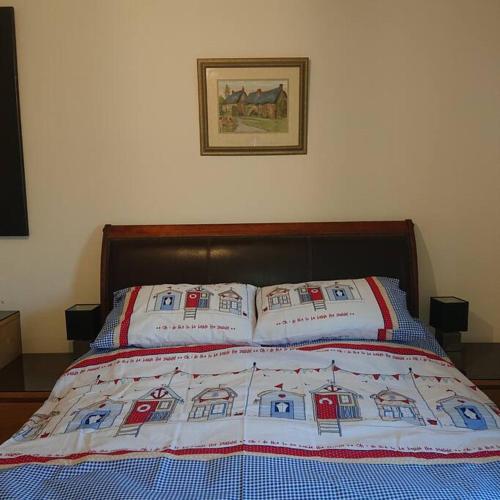 a bed with a quilt on top of it at Stylish 2 bed flat at Camber Sands in Camber