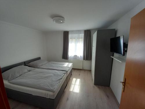 1 dormitorio con 1 cama y TV de pantalla plana en Wunderschönes 2Zimmer Apartment in Sbg, en Salzburgo