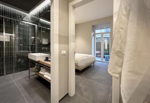 a bathroom with a shower and a sink and a bed at Casa Esmeralda in La Spezia