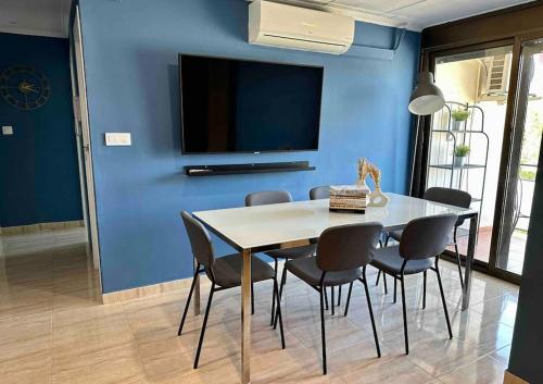 een eetkamer met een tafel en stoelen en een blauwe muur bij Minutes to the beach, near Convention Centre and free parking in Barcelona