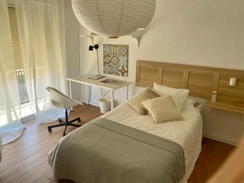 a bedroom with a bed with a desk and a chair at Guest house Croqueta Espinardo in Espinardo