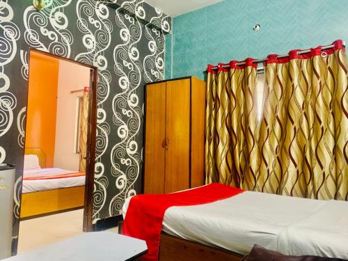 a bedroom with two beds and a mirror at Hotel Bengal in Kolkata