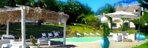 een zwembad met stoelen en een parasol bij Luxury bnb Le Rocce in Villasmundo