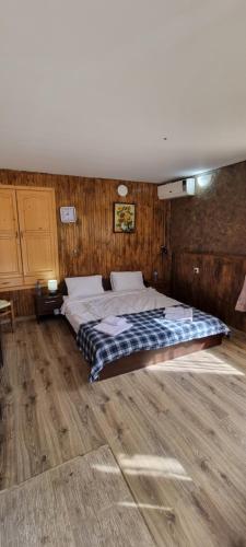 a large bed in a room with a wooden floor at sunny day in Krushuna